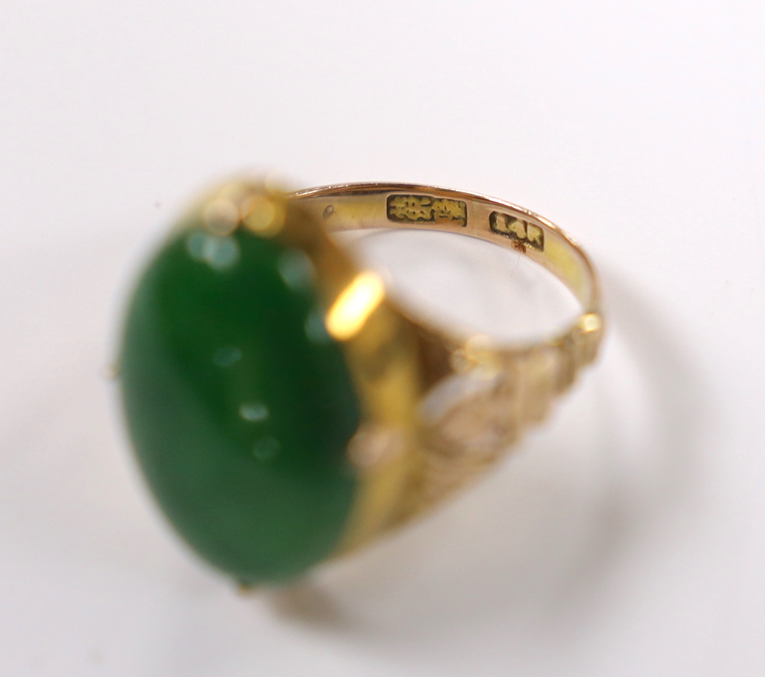 A Chinese 14k yellow metal and oval cabochon jade set ring, size I, gross weight 5.4 grams.